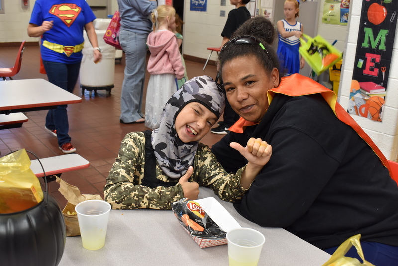 Families at food table.