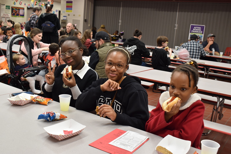 Families at food table.