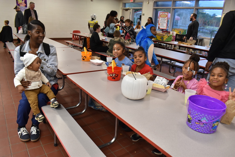 Families at food table.