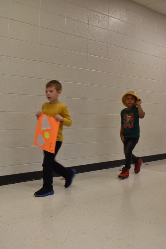 Students wearing costumes to represent letters of the alphabet in a parade.