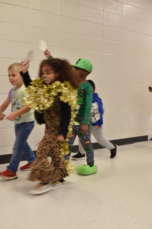 Students wearing costumes to represent letters of the alphabet in a parade.
