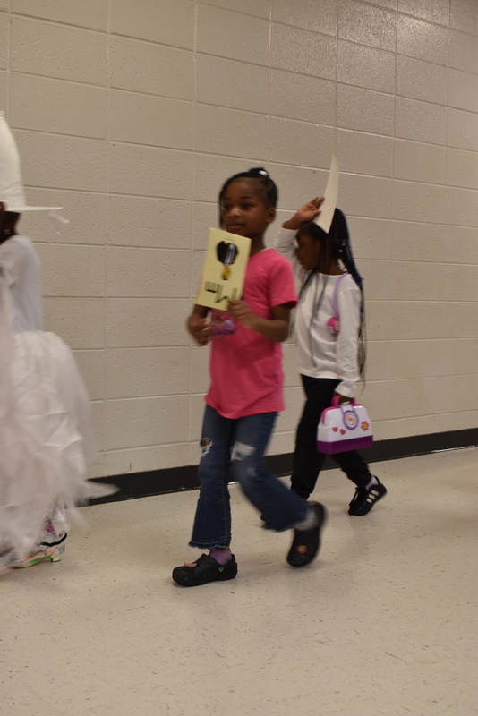 Students wearing costumes to represent letters of the alphabet in a parade.