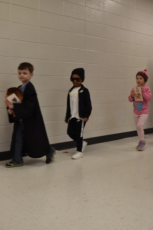 Students wearing costumes to represent letters of the alphabet in a parade.