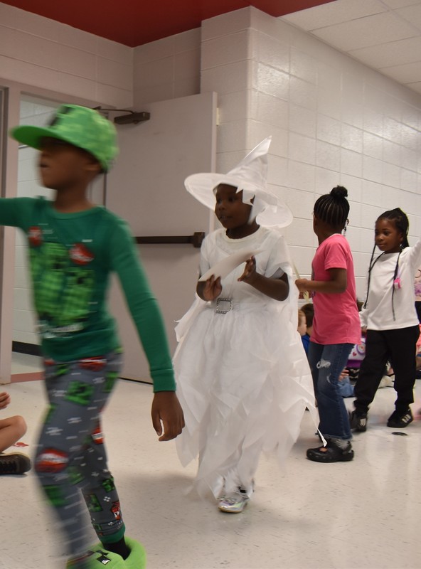 Students wearing costumes to represent letters of the alphabet in a parade.