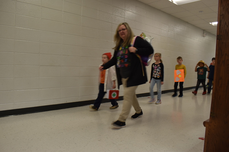 Students wearing costumes to represent letters of the alphabet in a parade.