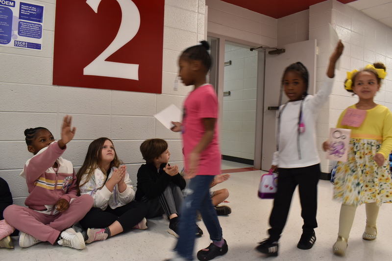 Students wearing costumes to represent letters of the alphabet in a parade.