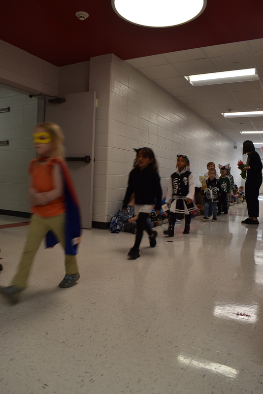 Students wearing costumes to represent letters of the alphabet in a parade.