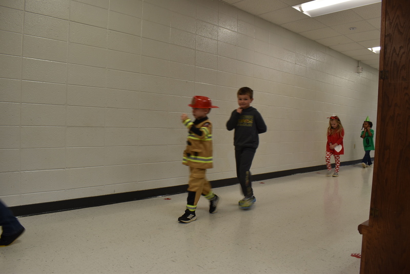 Students wearing costumes to represent letters of the alphabet in a parade.