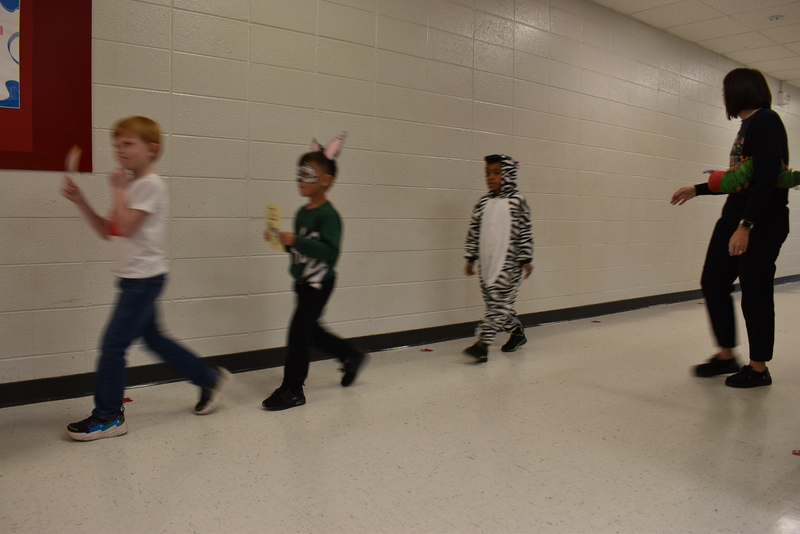 Students wearing costumes to represent letters of the alphabet in a parade.
