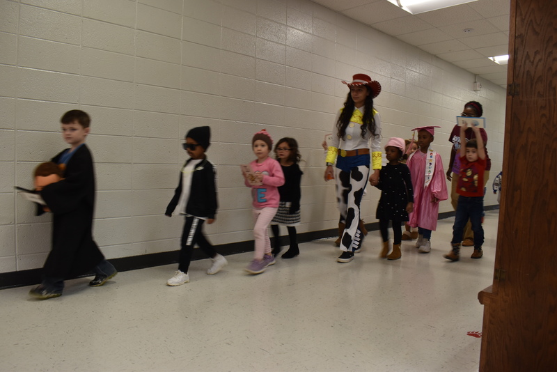 Students wearing costumes to represent letters of the alphabet in a parade.