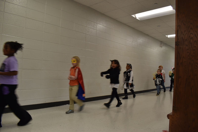 Students wearing costumes to represent letters of the alphabet in a parade.