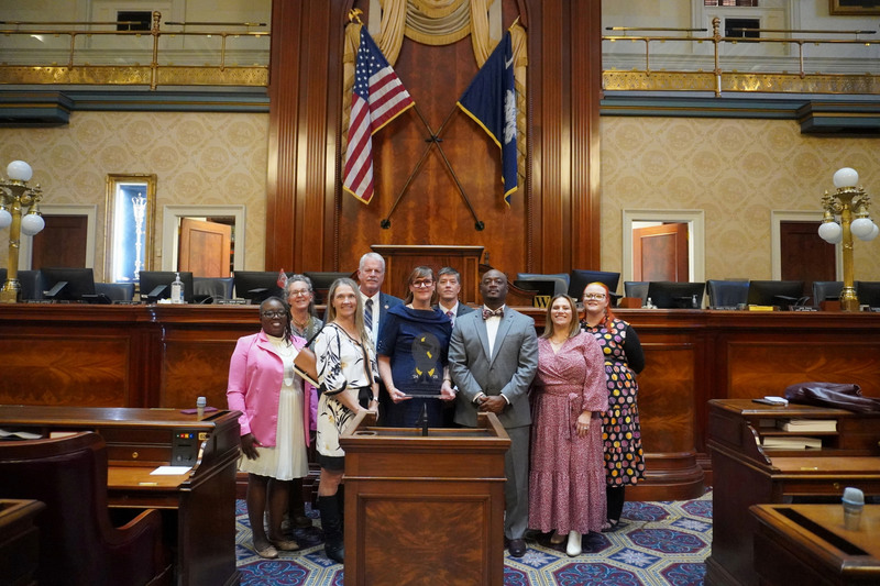 Aiken team posed together under the US and SC flags.