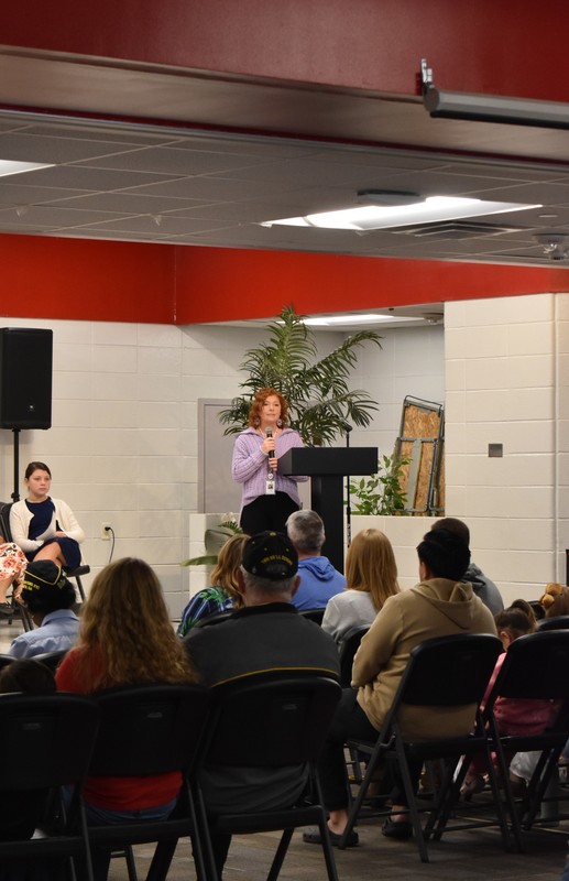 Principal addressing crowd.