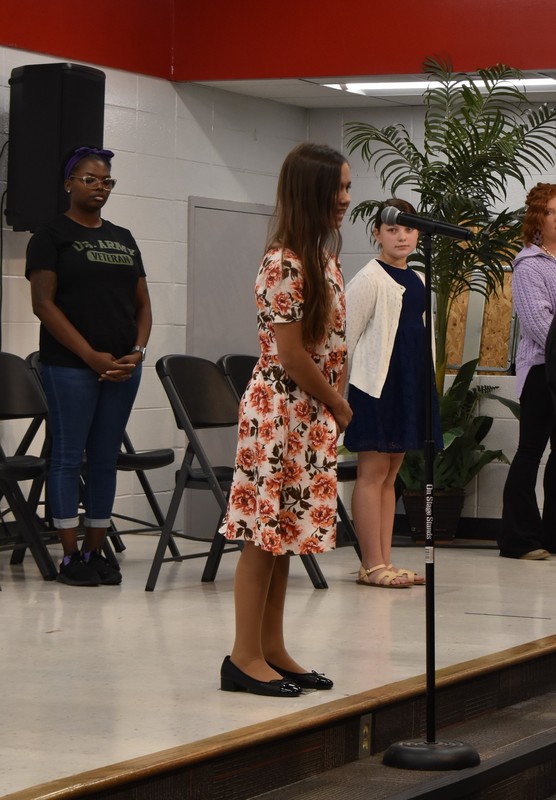Student singing National Anthem.