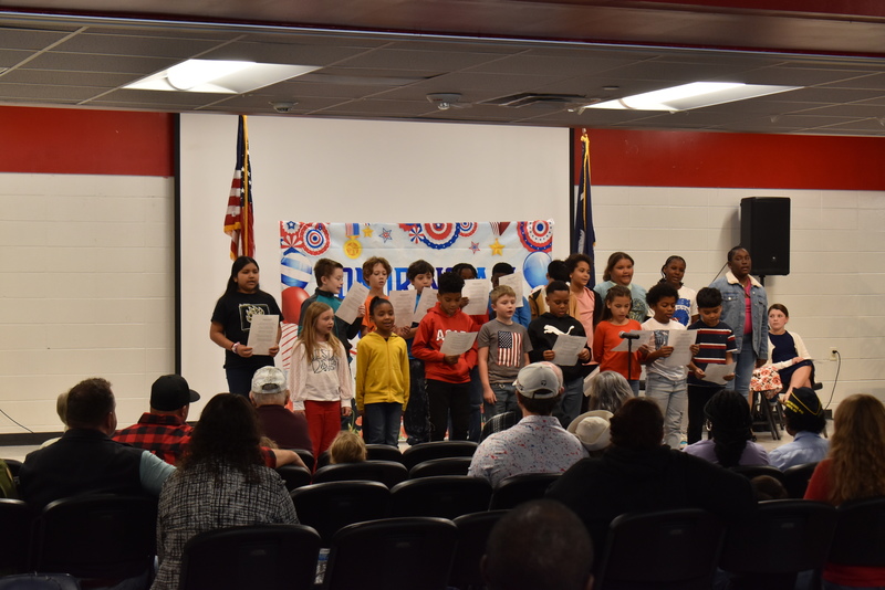 Class singing for crowd.