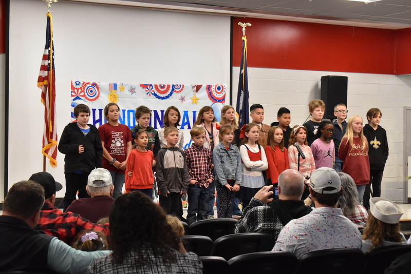 Class singing for crowd.