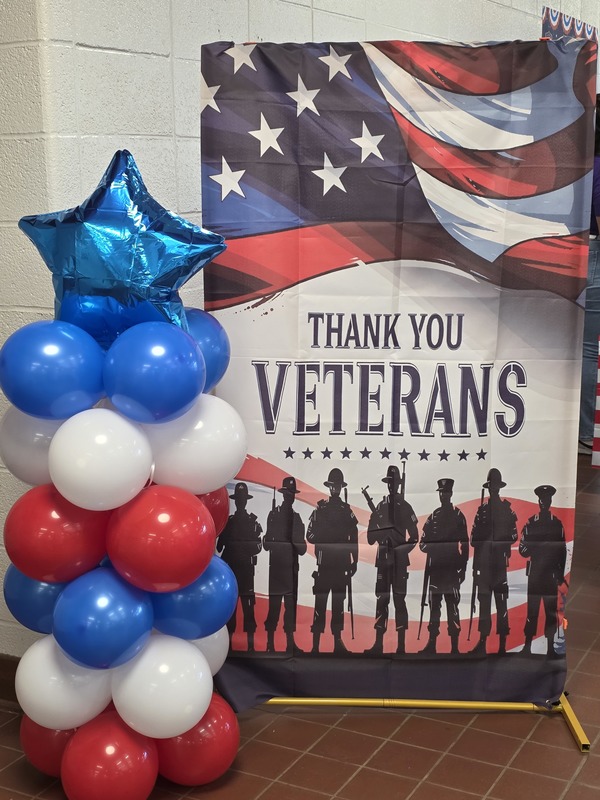 "Thank you Veterans" sign with balloons beside it.
