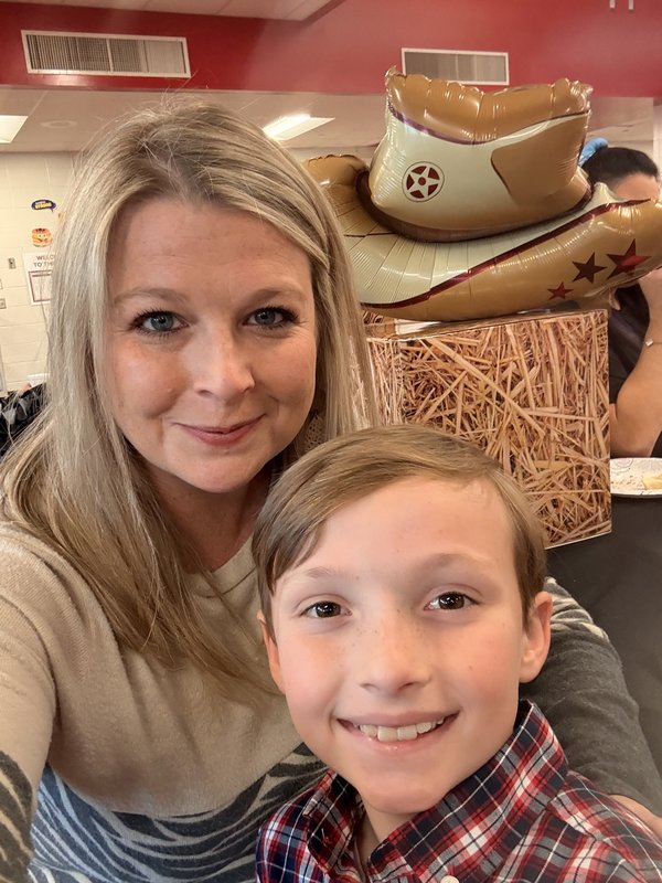 Mother and son at rodeo sign.