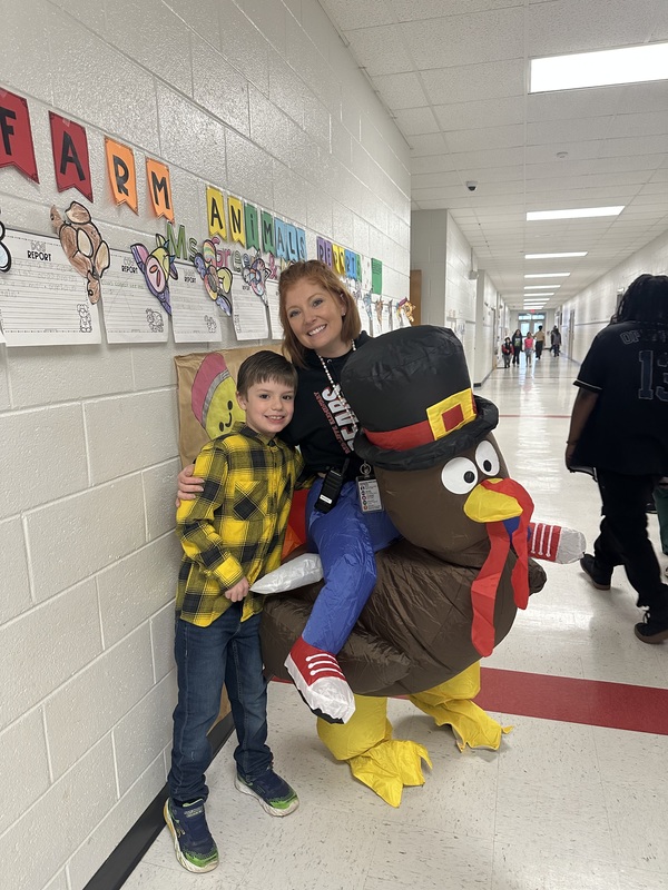 Principal in turkey costume with student.