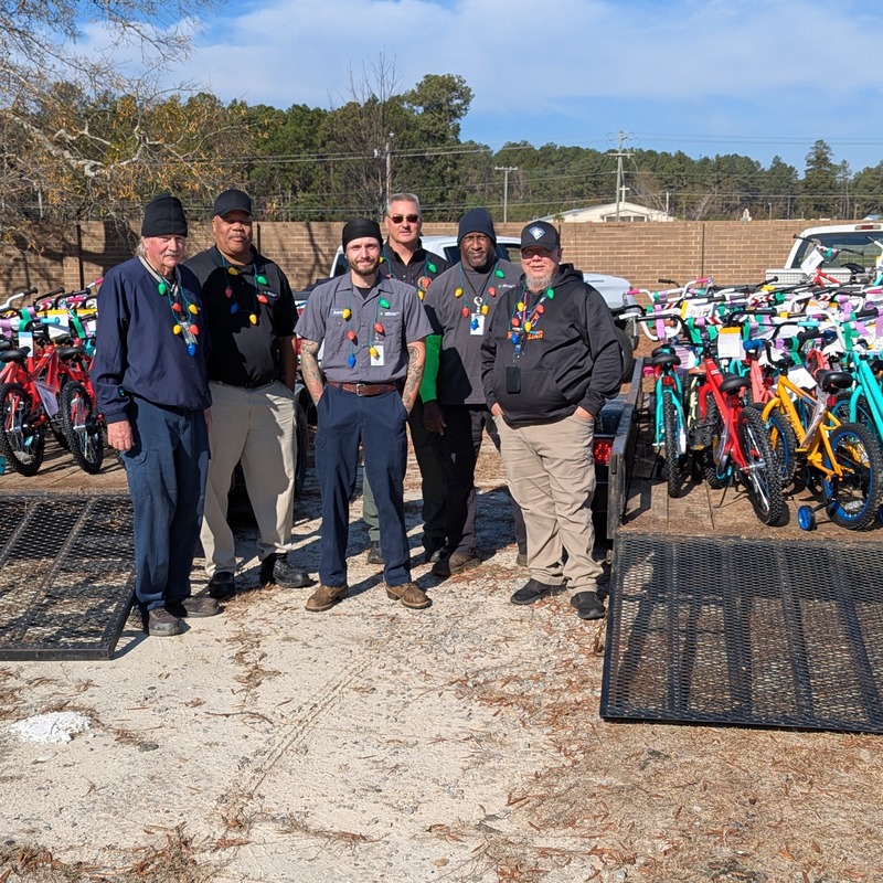Group of men picking up bikes to be delivered to schools.