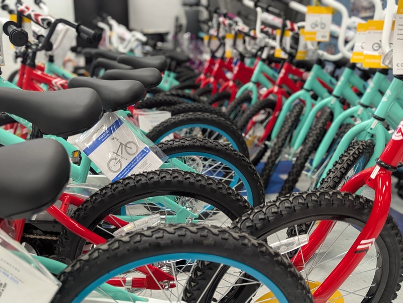 Red and green bicycles lined up in two rows waiting to be picked up.