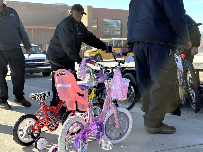 Men loading bikes onto a trailer to be delivered to students.