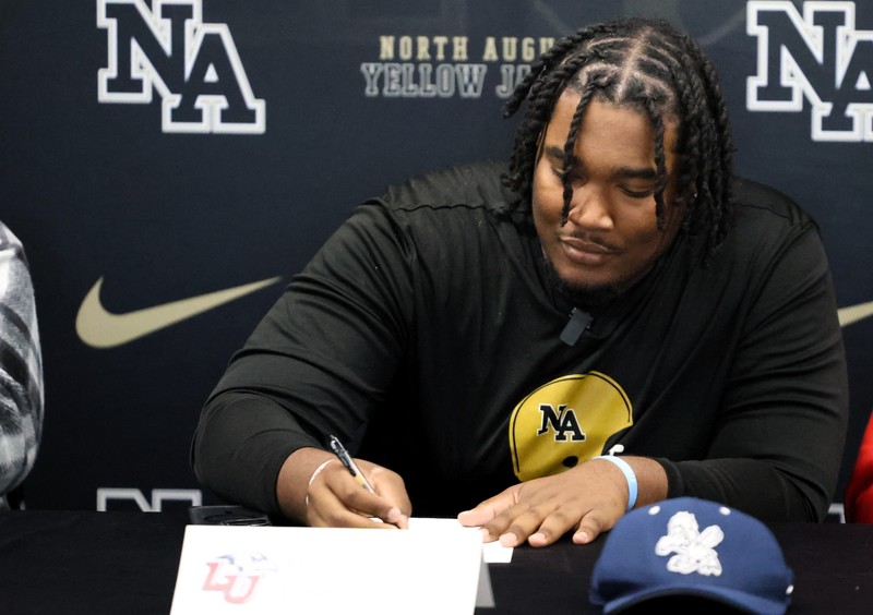 Man signing form in front of NAHS display.