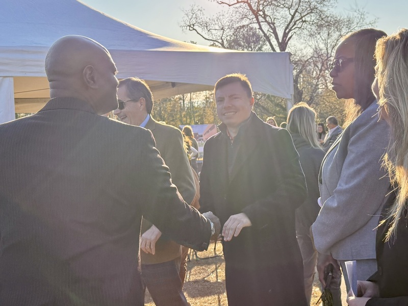Two men shaking hands while two women look on.