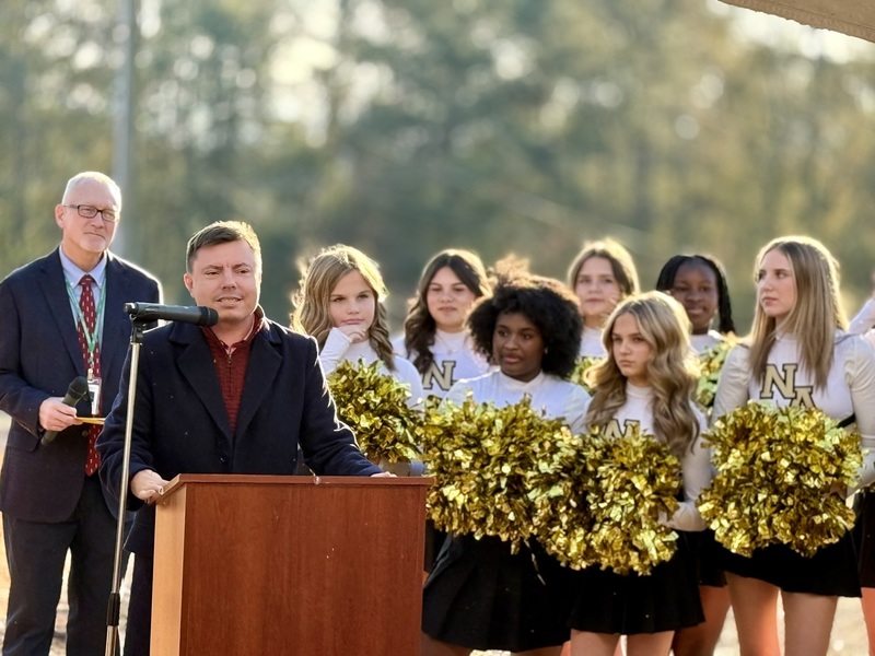 Speaker at a podium celebrating new school and groundbreaking.