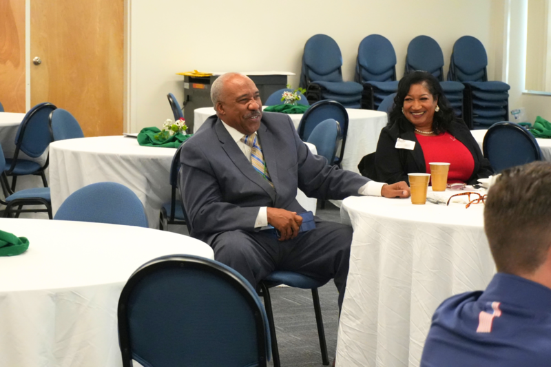 Participators laughing while seated at table.