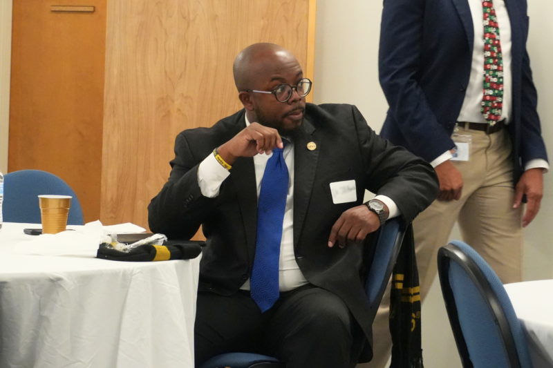 Participator sitting at table listening to discussion.