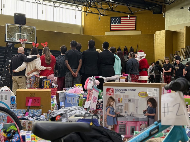Student's standing around a Christmas tree at an assembly.