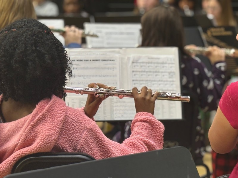 Student playing an instrument during a school assembly.