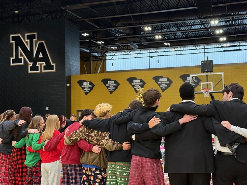 Students standing in a group in a gymnasium.