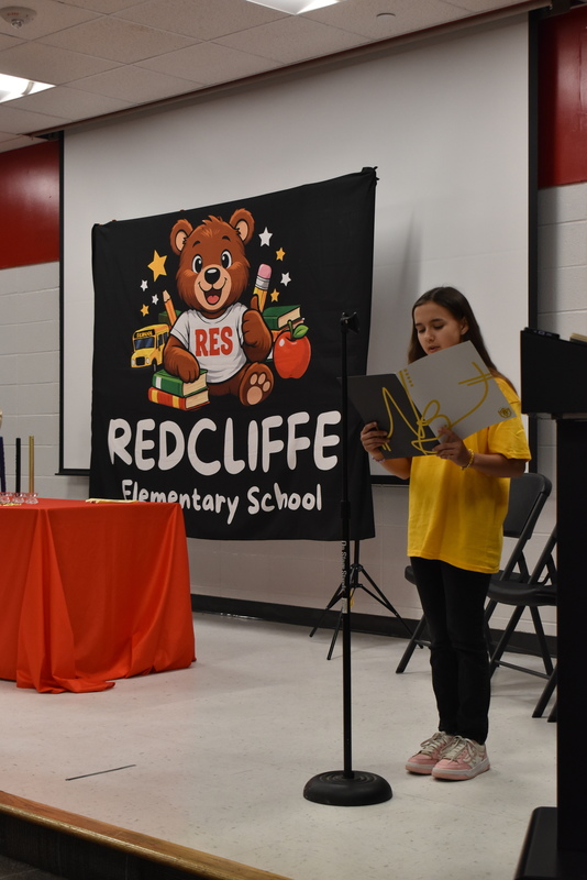 Student reading from folder.