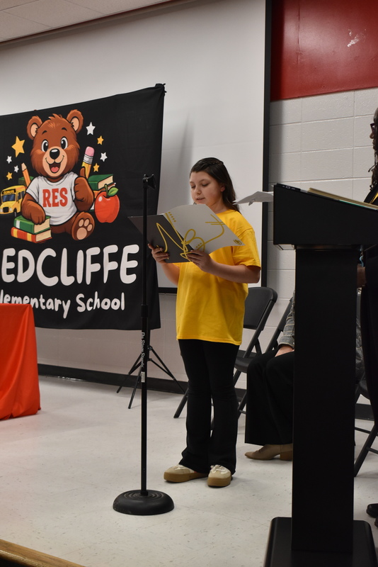 Student reading from folder.