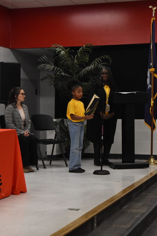 Student reading from folder.