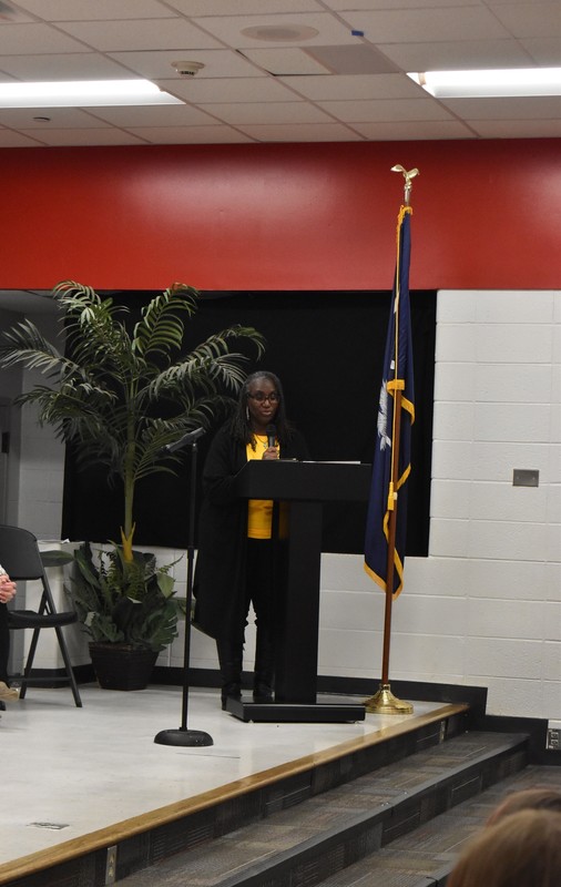 Teacher speaking into microphone.