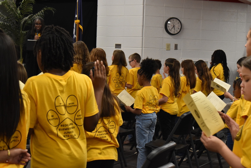 Students standing in audience.