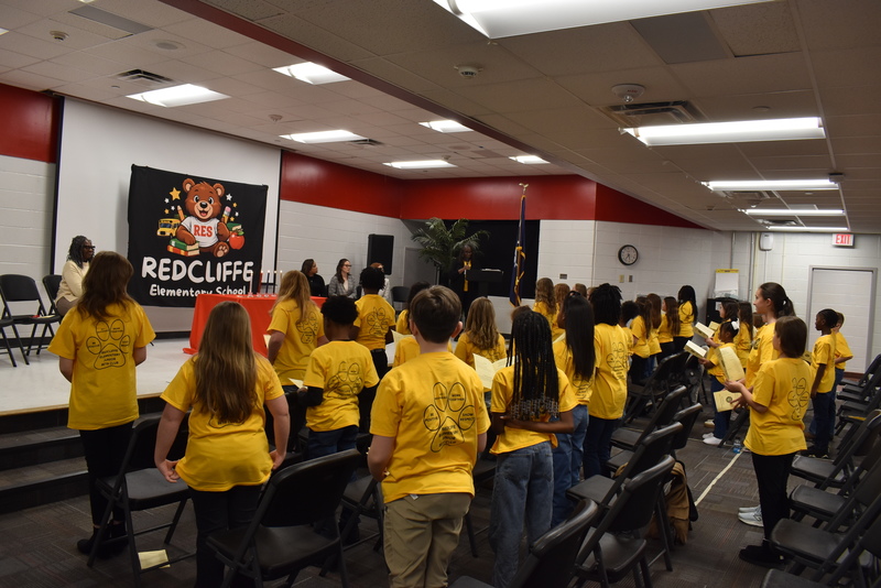 Students standing in audience.