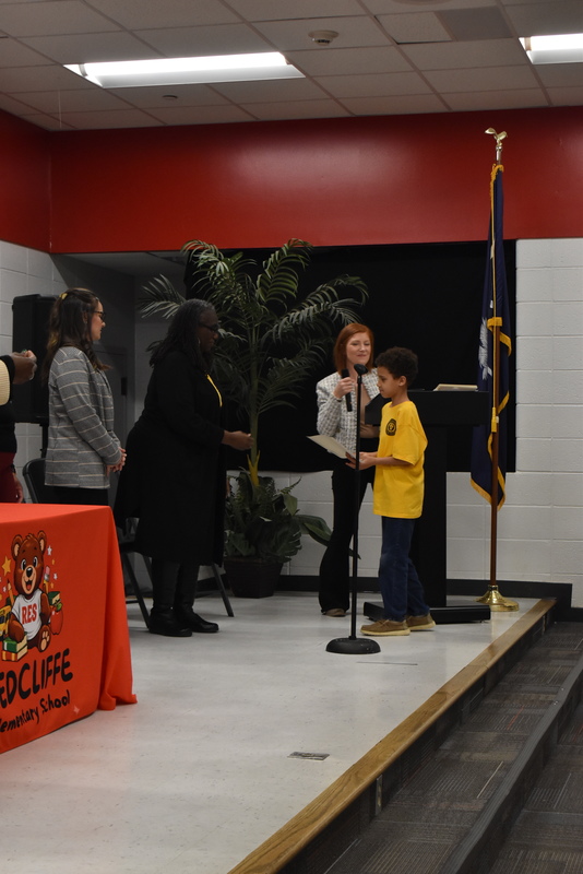 Student on stage receiving certificate.