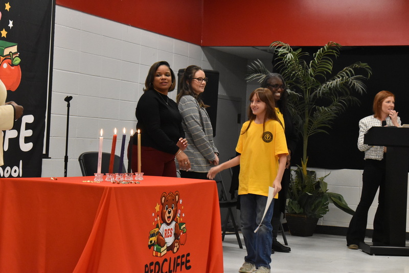 Student on stage shaking hands with staff.