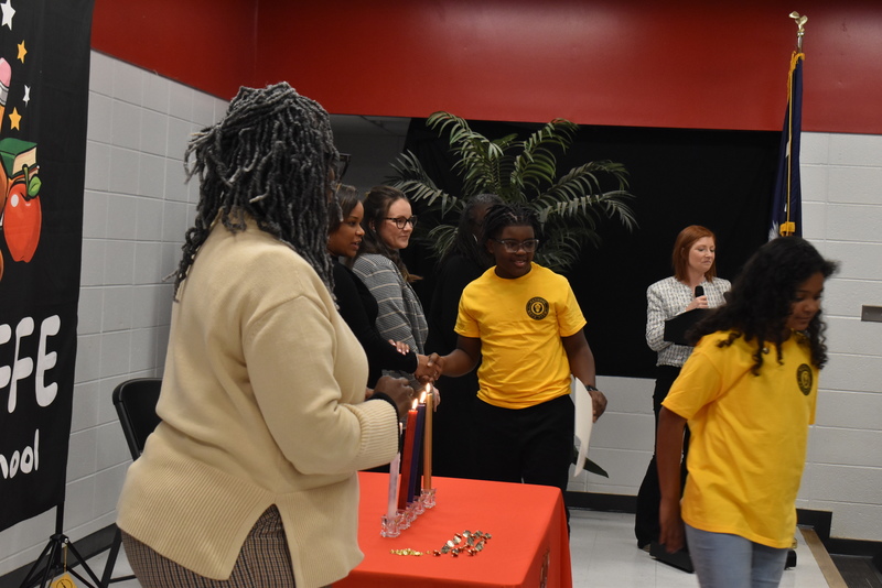Student on stage shaking hands with staff.