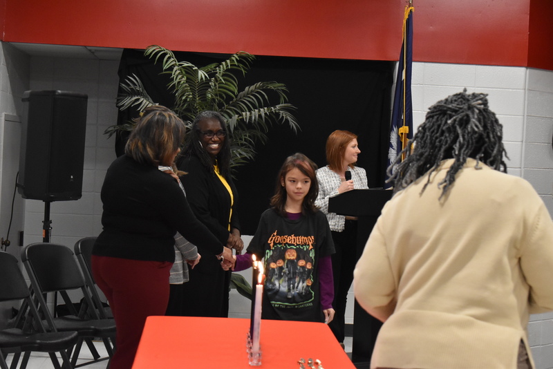 Student on stage shaking hands with staff.