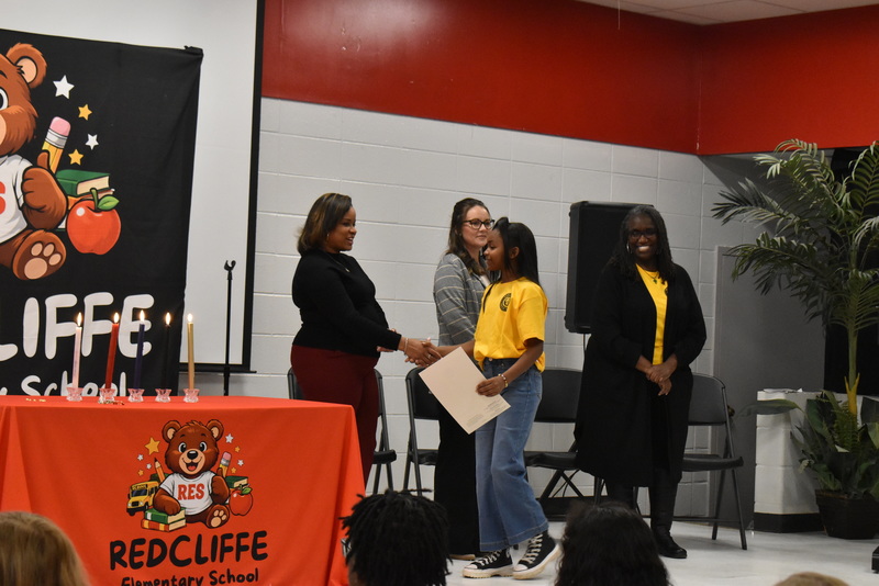 Student shaking hands with staff.