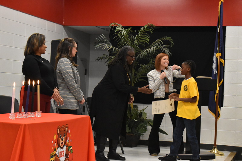 Student shaking hands with staff.