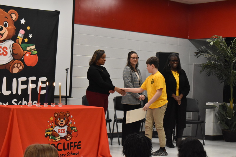 Student shaking hands with staff.