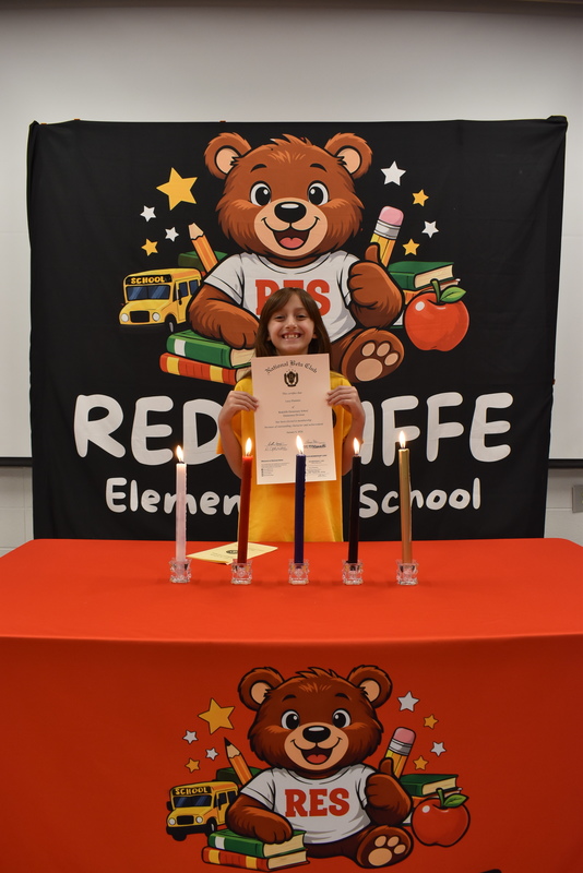 Student standing behind candles.