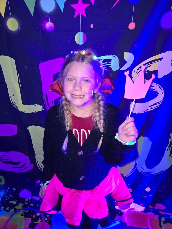 Students in glow party photo booth.