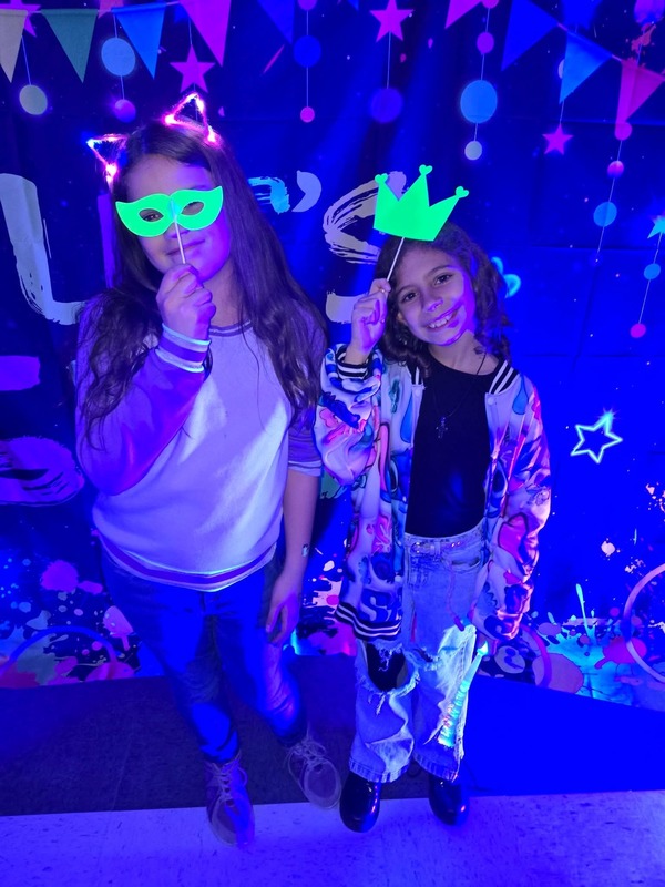 Students in glow party photo booth.